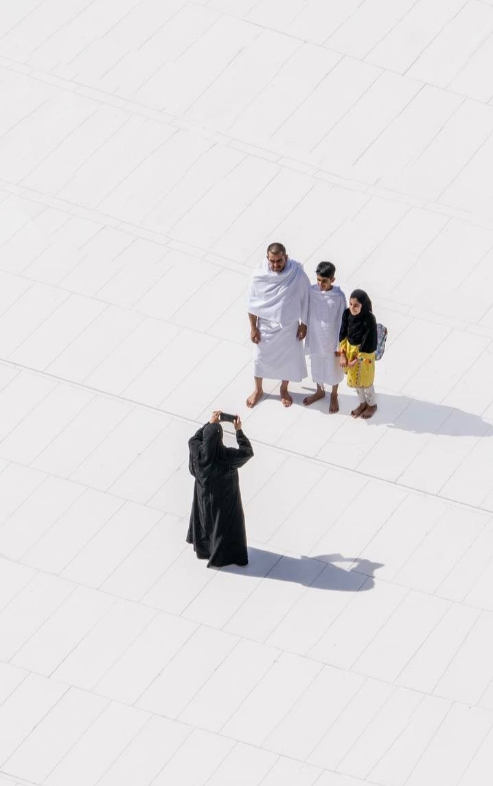 A family in ihram on the white marble of the Haram